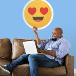 Man showing heart eyes emoticon on couch